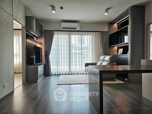Modern living room with sleek design, large windows, and stylish furniture in a contemporary apartment.