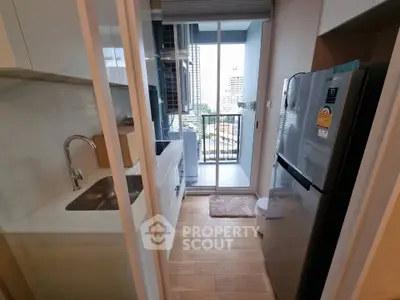 Modern kitchen with sleek appliances and balcony view in urban apartment