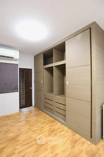 Spacious bedroom with modern wooden wardrobe and sleek flooring