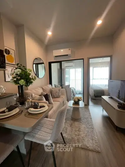 Modern living room with stylish decor and open layout leading to a cozy bedroom.