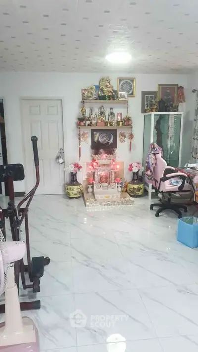 Spacious living area with marble flooring and decorative shelves