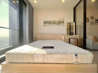 Spacious bedroom with large windows and modern furniture, offering a bright and inviting atmosphere.