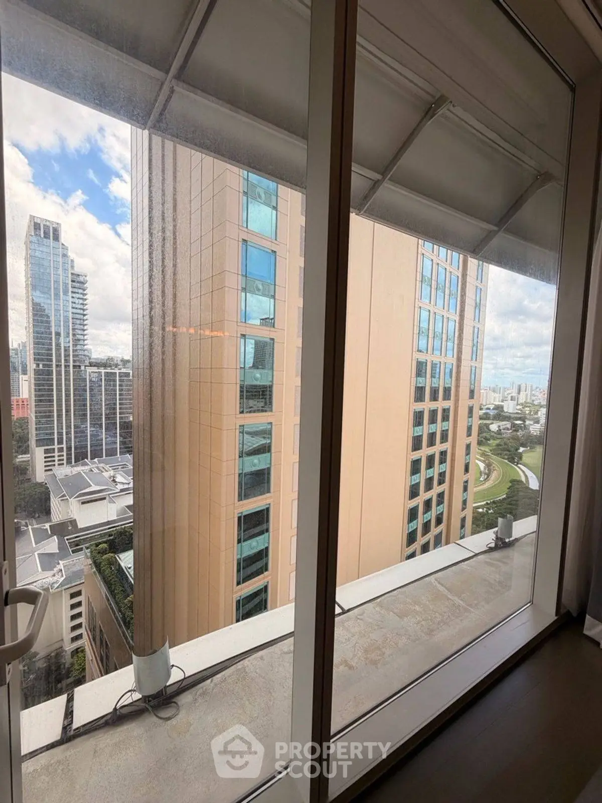 Stunning high-rise view from modern apartment window showcasing city skyline.