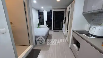 Modern studio apartment with sleek kitchen and cozy bedroom area