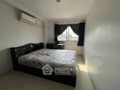 Spacious bedroom with natural light and modern furnishings, ideal for comfortable living.