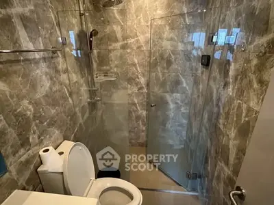 Modern bathroom with marble tiles and glass shower enclosure