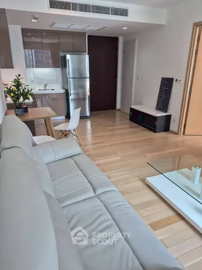 Modern living room with sleek kitchen and stylish furniture in open layout apartment.