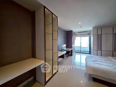 Spacious modern bedroom with sleek design and large windows offering natural light.