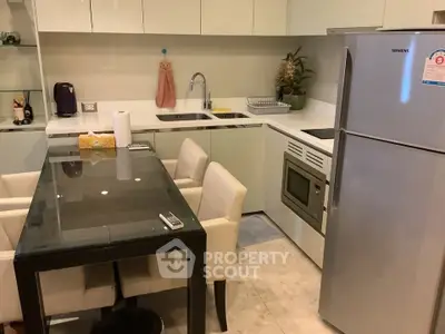 Modern kitchen with sleek appliances and dining area in a compact layout