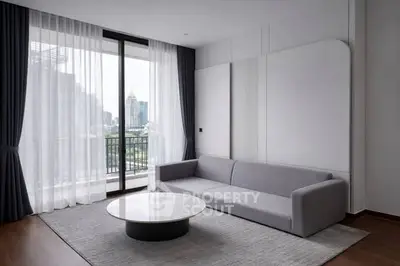 Modern living room with sleek gray sofa and city view balcony