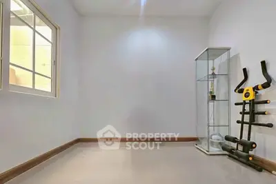 Minimalist room with exercise equipment and display cabinet, perfect for a home gym or study area.