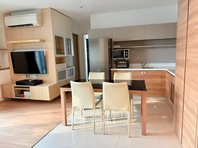 Modern open-layout kitchen and dining area with sleek appliances and stylish furniture.
