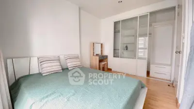 Spacious bedroom with modern design and ample storage in a bright apartment.
