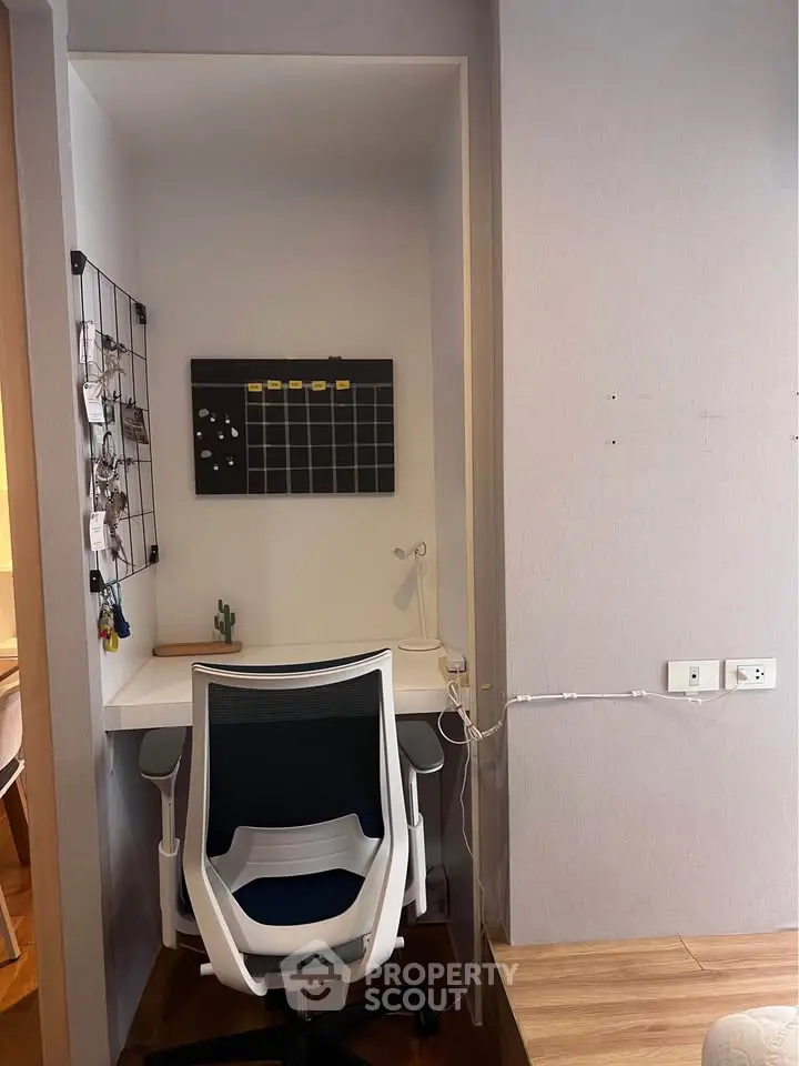 Cozy study nook with modern chair and wall organizer in stylish apartment.