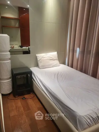 Cozy bedroom with single bed, wooden flooring, and modern decor, perfect for a minimalist lifestyle.