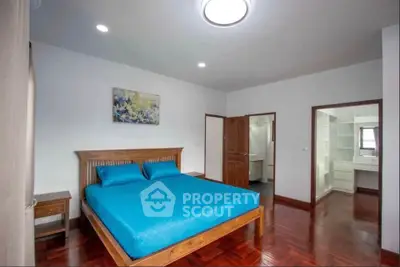 Spacious bedroom with wooden flooring and modern decor