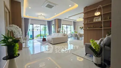 Luxurious open-plan living room with elegant decor and large windows offering garden views.