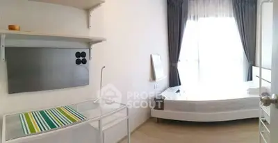 Bright minimalist bedroom with large window and modern furnishings.