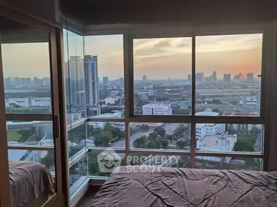 Stunning bedroom with panoramic city view at sunset, featuring floor-to-ceiling windows.