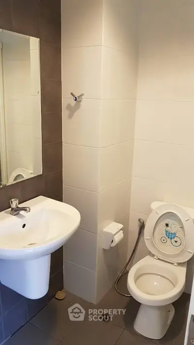 Compact bathroom with modern fixtures and neutral tiles