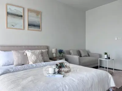 Modern bedroom with cozy decor and neutral tones, featuring a stylish bed and comfortable seating area.