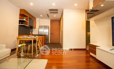 Modern open-plan living room with wooden flooring and stylish kitchen area.