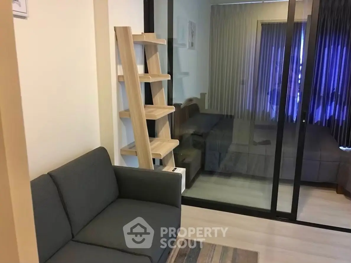 Modern apartment with cozy living room and bedroom separated by glass partition.