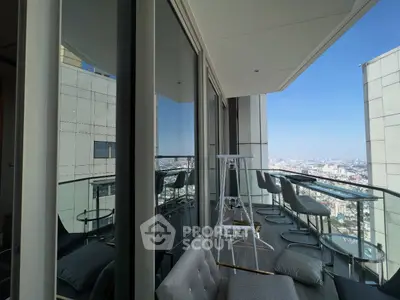Luxurious high-rise balcony with stunning city view and modern seating area.