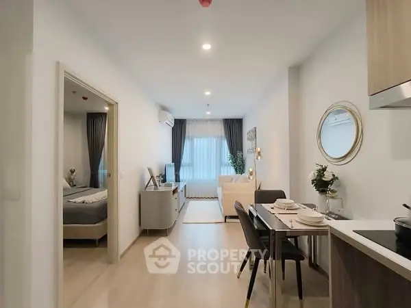 Modern open-plan living room with dining area and bedroom view