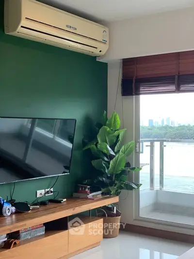Modern living room with air conditioning, TV, and balcony view of city skyline.