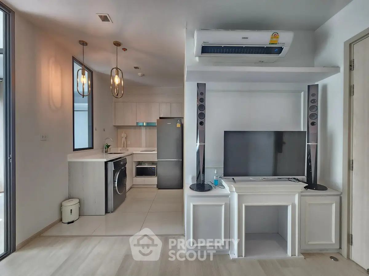 Modern open-plan living room with sleek kitchen and stylish appliances