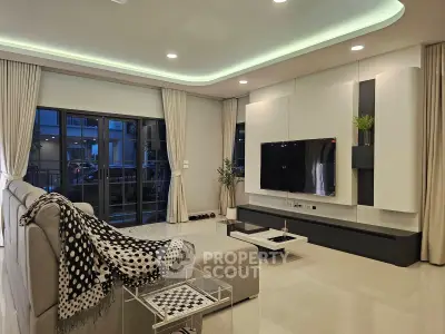 Luxurious modern living room with sleek design and large TV, perfect for relaxation and entertainment.