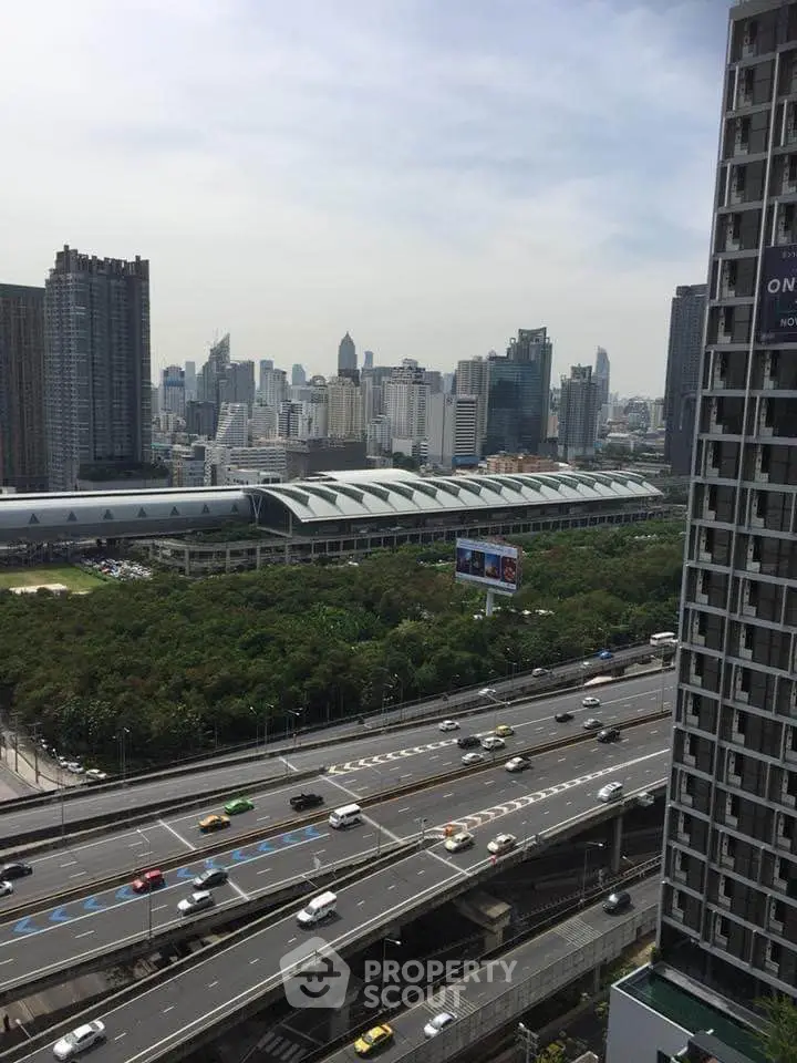 Stunning cityscape view from high-rise building overlooking bustling highway and urban skyline.