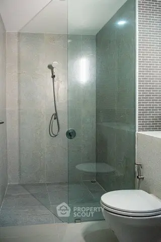 Modern bathroom with glass shower enclosure and sleek design.