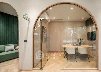 Modern interior with glass-walled study and elegant dining area, featuring stylish decor and natural light.