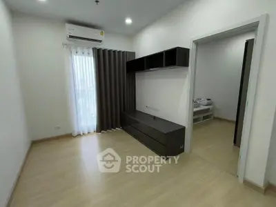 Modern living room with sleek black furniture and natural light from large window.