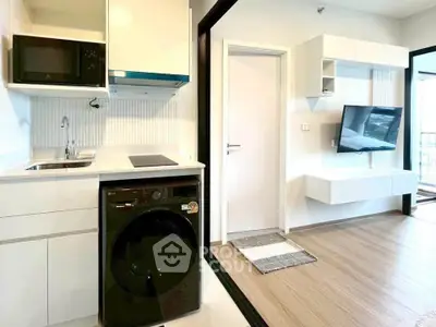 Modern apartment interior with sleek kitchen and cozy living area featuring wall-mounted TV.