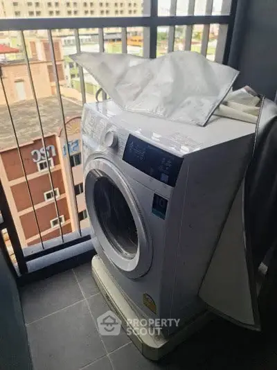 Modern washing machine on a balcony with city view, perfect for urban living convenience.
