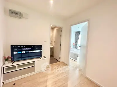 Modern apartment interior with TV, bathroom, and bedroom access, showcasing sleek design and cozy ambiance.