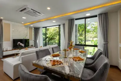 Luxurious open-plan living and dining area with garden view, featuring elegant decor and modern furnishings.