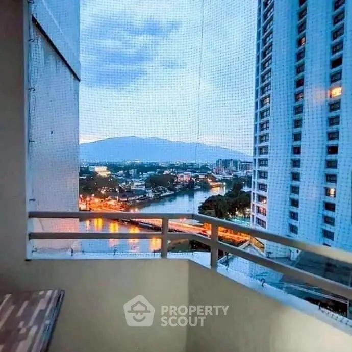 Stunning balcony view of city skyline and river at dusk, perfect for urban living.