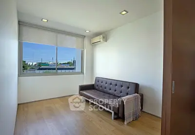Modern minimalist room with sleek sofa and large window offering scenic views.