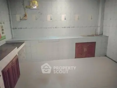 Spacious kitchen with tiled walls and ample counter space, ideal for culinary enthusiasts.