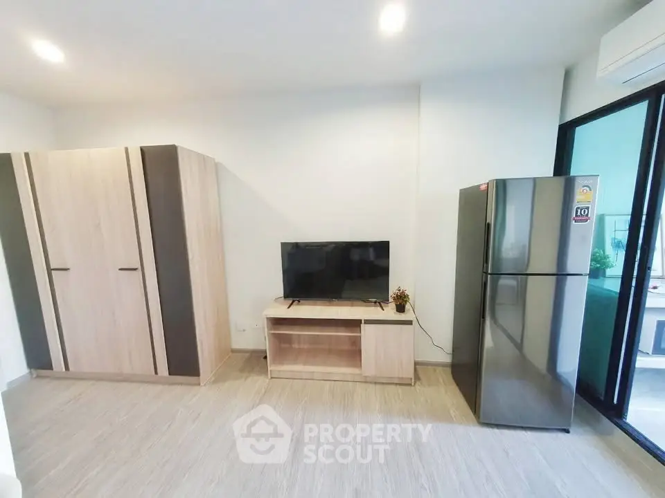 Modern living room with sleek TV stand and large refrigerator