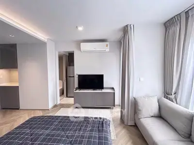 Modern bedroom with sleek design, featuring a cozy sofa, flat-screen TV, and air conditioning for ultimate comfort.