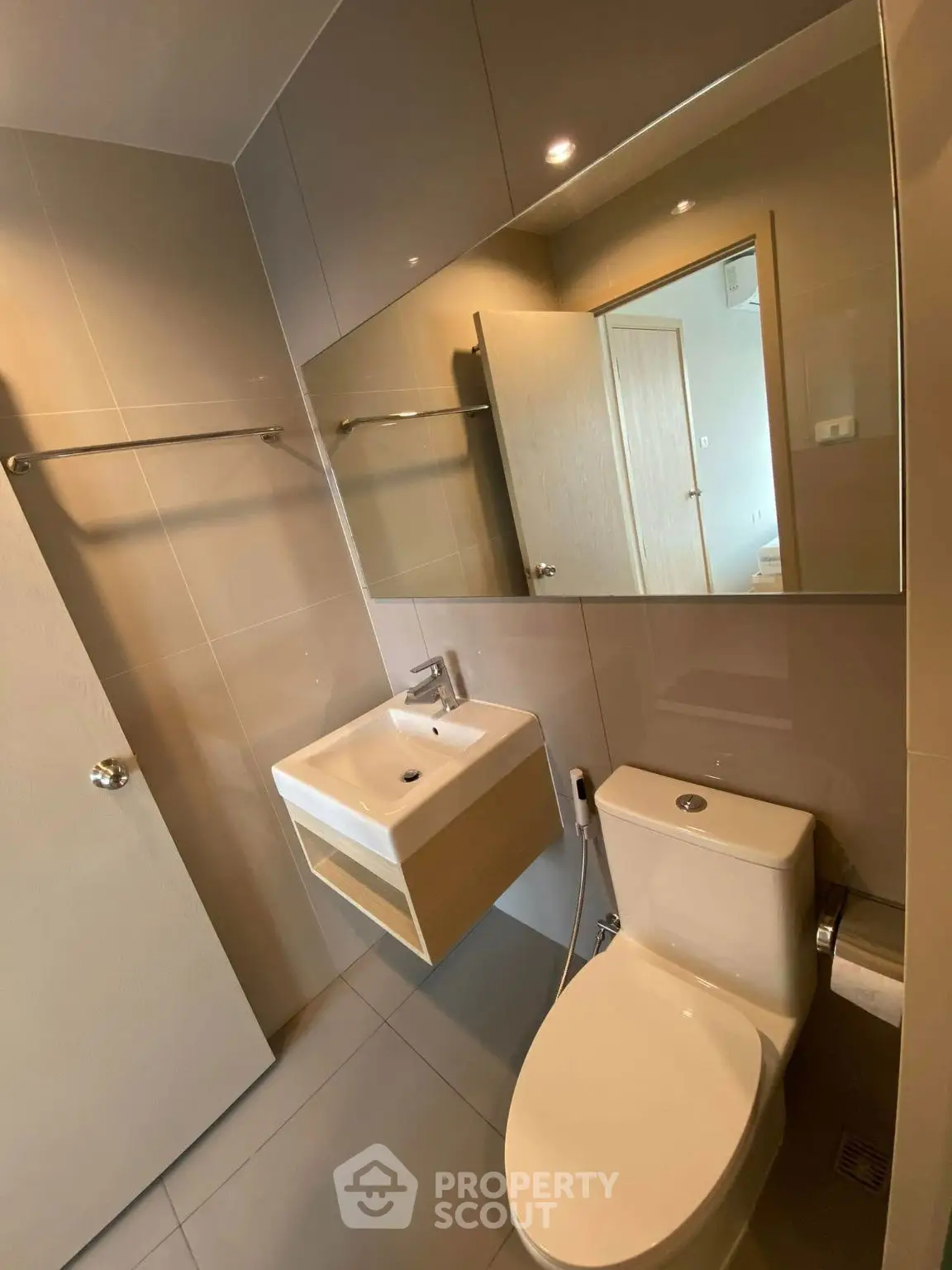 Modern bathroom with sleek fixtures and large mirror in a contemporary apartment.