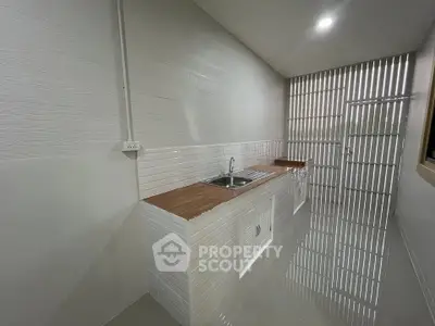 Modern kitchen with sleek white tiles and wooden countertops