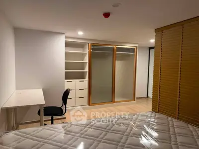 Spacious bedroom with modern closet and study area, perfect for comfortable living.