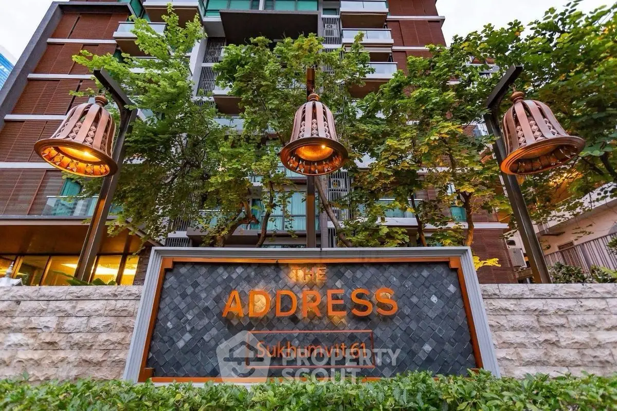 Modern condominium entrance with stylish lighting and lush greenery at Sukhumvit 61.