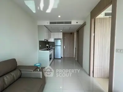 Modern apartment interior with sleek kitchen and cozy living area, featuring contemporary design and ample natural light.